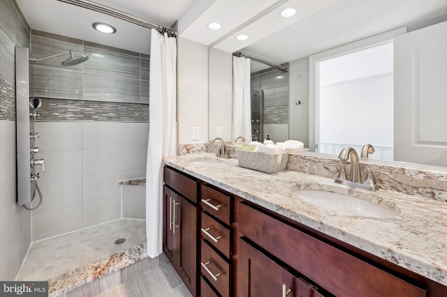 full bath with recessed lighting, tiled shower, and a sink