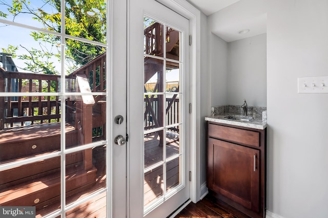 entryway with a sink, baseboards, dark wood-style flooring, and wet bar