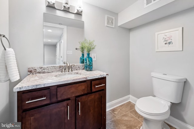 half bath with toilet, baseboards, visible vents, and vanity