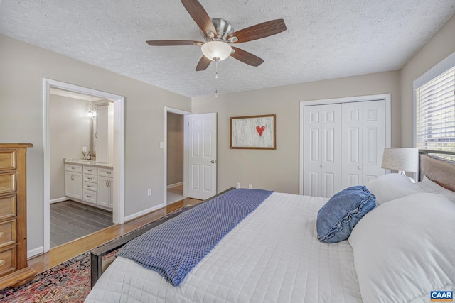 bedroom with ceiling fan, a textured ceiling, wood finished floors, baseboards, and a closet