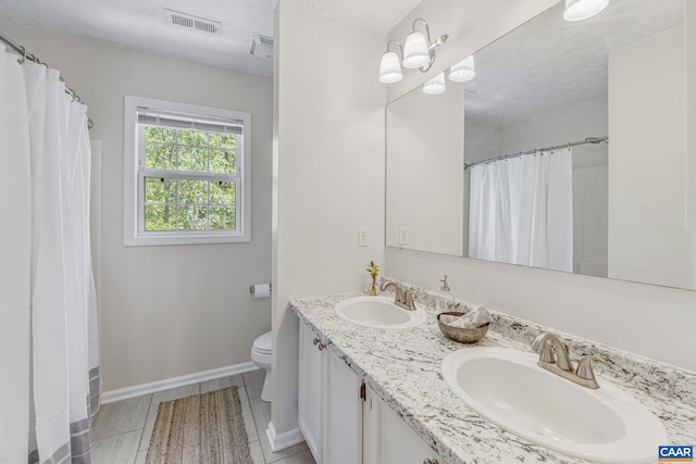 bathroom featuring toilet, baseboards, visible vents, and a sink