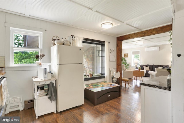 21194 Main St, Shade Gap, PA 17255 - kitchen with freestanding refrigerator, a wall mounted air conditioner, dark wood-style flooring, baseboard heating, and dark stone counters