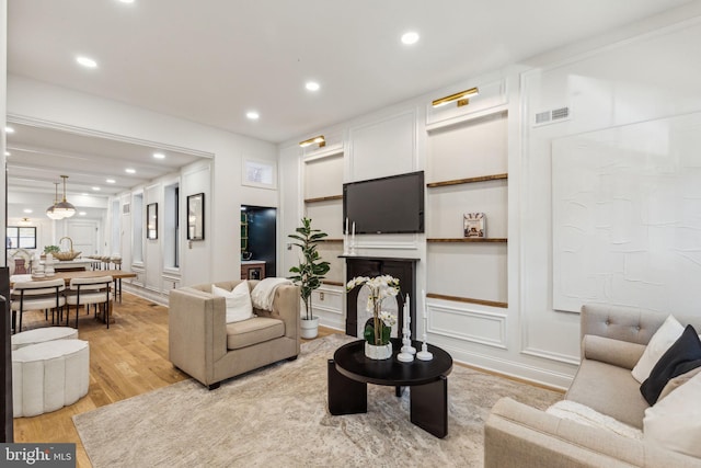 213 Morris St, Philadelphia, PA 19148 - living room featuring visible vents, recessed lighting, a decorative wall, and light wood-type flooring