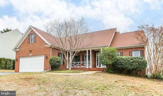 view of front of house with an attached garage, brick siding, a porch, a front yard, and driveway