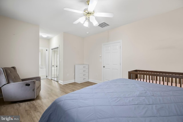bedroom featuring visible vents, wood finished floors, baseboards, ceiling fan, and connected bathroom