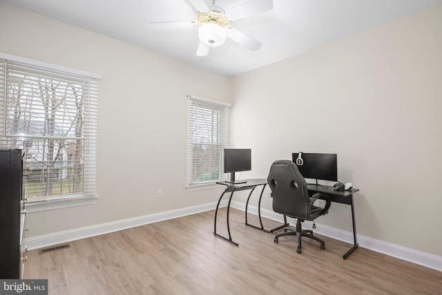office area featuring baseboards, visible vents, and wood finished floors