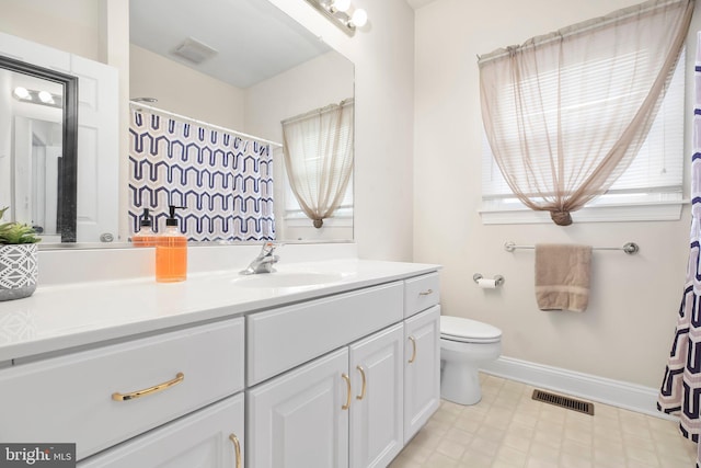 bathroom featuring visible vents, vanity, baseboards, tile patterned floors, and toilet