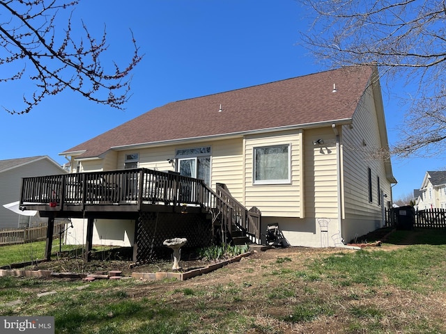 back of property with a wooden deck, fence, a shingled roof, a yard, and stairway