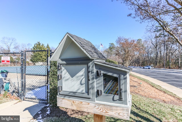 exterior space with a gate, uncovered parking, and fence