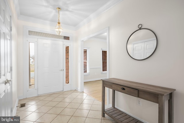 foyer entrance featuring baseboards, ornamental molding, and light tile patterned floors