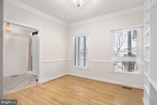spare room featuring visible vents, ornamental molding, and a wealth of natural light