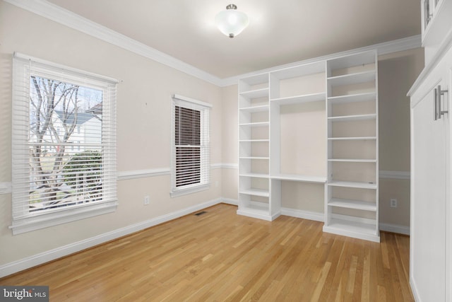 unfurnished bedroom with baseboards, light wood finished floors, crown molding, and visible vents