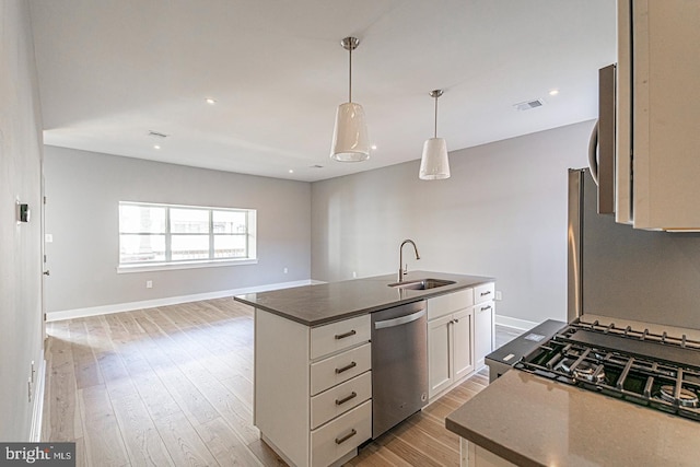 5412 Chancellor St, Philadelphia, PA 19139 - kitchen with dark countertops, a sink, dishwasher, visible vents, and a center island with sink