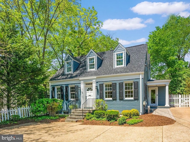 new england style home with fence and roof with shingles