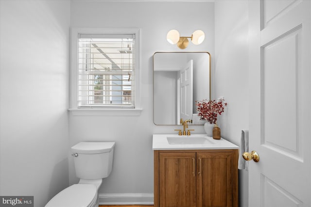 half bathroom featuring vanity and toilet