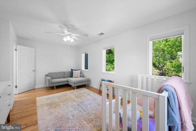 bedroom featuring visible vents, light wood finished floors, ceiling fan, and baseboards