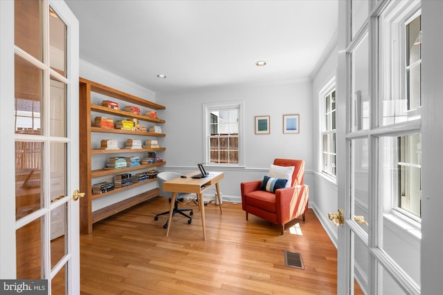 home office featuring french doors, visible vents, baseboards, light wood-style floors, and ornamental molding