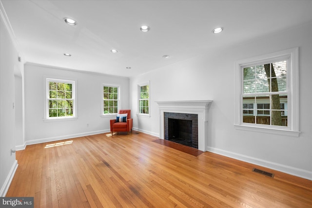 unfurnished living room featuring visible vents, a fireplace, baseboards, light wood-style floors, and recessed lighting
