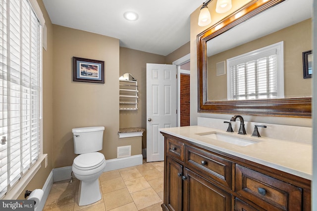 bathroom featuring vanity, toilet, tile patterned floors, baseboards, and visible vents