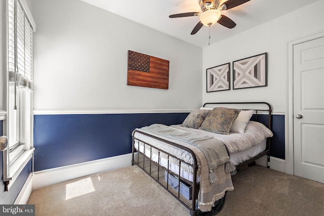 carpeted bedroom featuring baseboards and ceiling fan