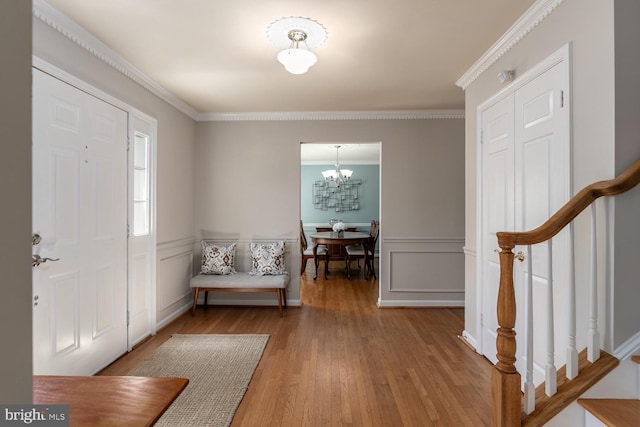 10808 Fieldwood Dr, Fairfax, VA 22030 - entryway featuring a chandelier, crown molding, wood finished floors, a wainscoted wall, and stairs