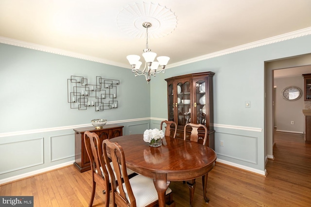 10808 Fieldwood Dr, Fairfax, VA 22030 - dining room with light wood finished floors, a decorative wall, a chandelier, ornamental molding, and wainscoting