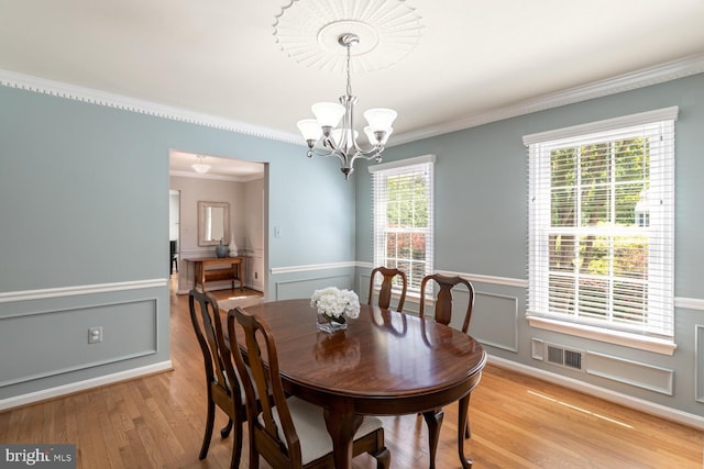10808 Fieldwood Dr, Fairfax, VA 22030 - dining area with ornamental molding, a chandelier, light wood-type flooring, a wainscoted wall, and a decorative wall