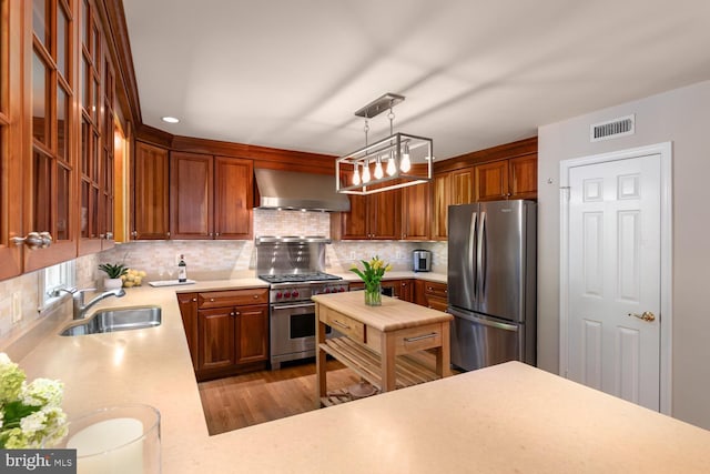 10808 Fieldwood Dr, Fairfax, VA 22030 - kitchen with appliances with stainless steel finishes, wall chimney exhaust hood, a sink, light countertops, and tasteful backsplash