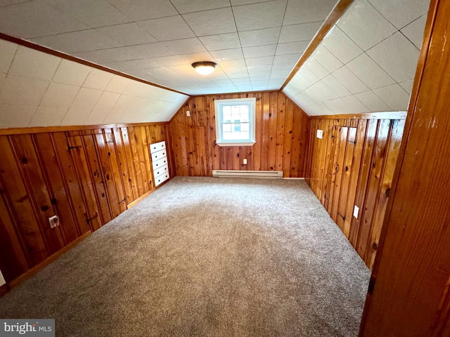 additional living space featuring a baseboard radiator, carpet flooring, vaulted ceiling, and wooden walls
