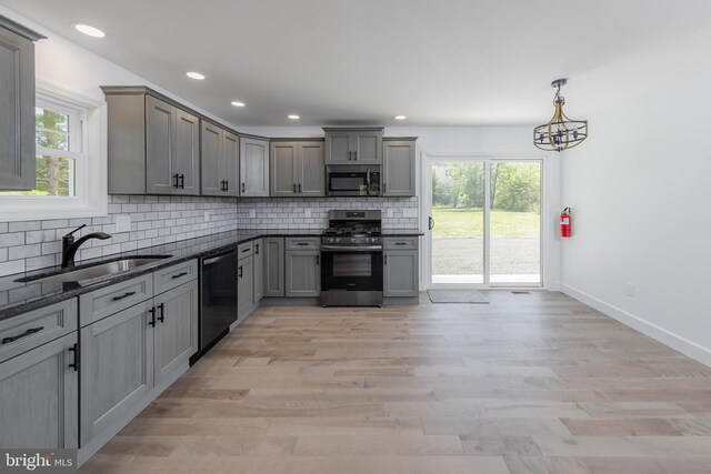 kitchen featuring backsplash, appliances with stainless steel finishes, a healthy amount of sunlight, and a sink