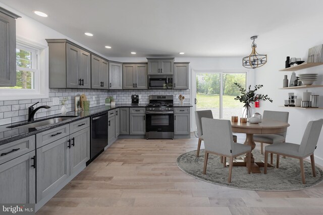 kitchen featuring a sink, appliances with stainless steel finishes, a wealth of natural light, and gray cabinetry