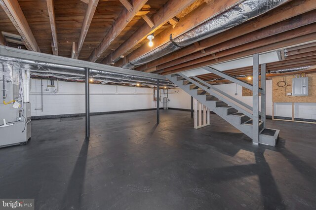 unfinished basement with heating unit and stairway