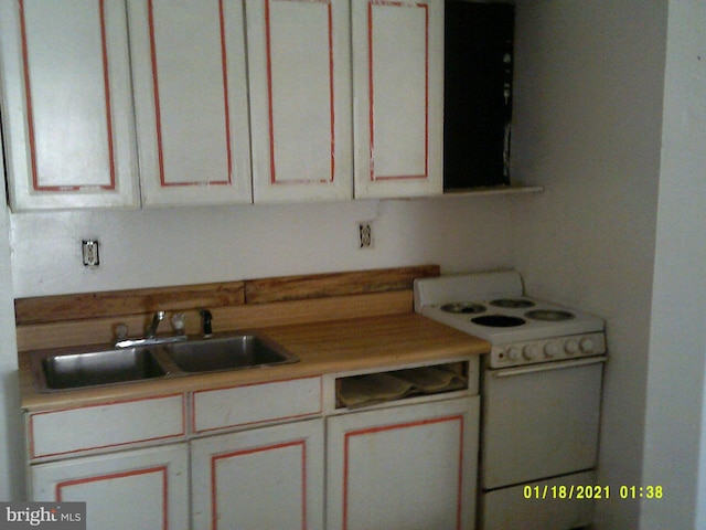 kitchen with light countertops, electric range, and a sink