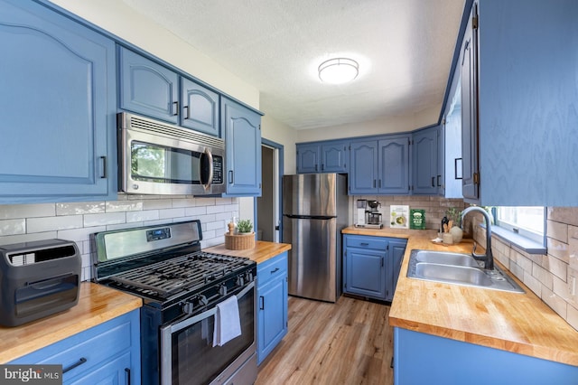 475 Farmington Ave, Pottstown, PA 19464 - kitchen featuring stainless steel appliances, a sink, blue cabinets, wooden counters, and a textured ceiling