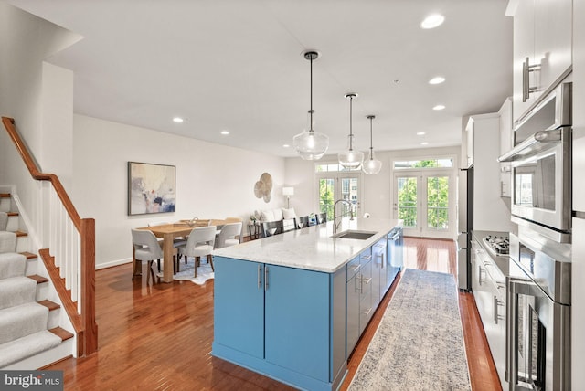 20790 Duxbury Ter, Ashburn, VA 20147 - kitchen featuring blue cabinetry, dark wood-type flooring, white cabinets, recessed lighting, and appliances with stainless steel finishes