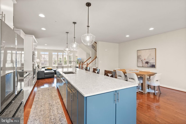 20790 Duxbury Ter, Ashburn, VA 20147 - kitchen featuring blue cabinets, wood finished floors, recessed lighting, a spacious island, and stainless steel appliances
