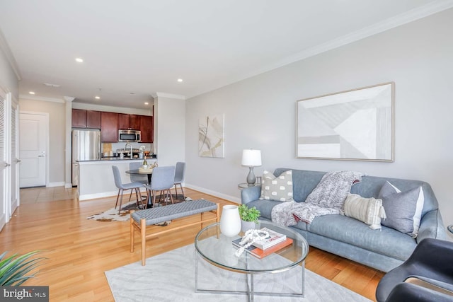 living area with recessed lighting, baseboards, ornamental molding, and light wood-style flooring