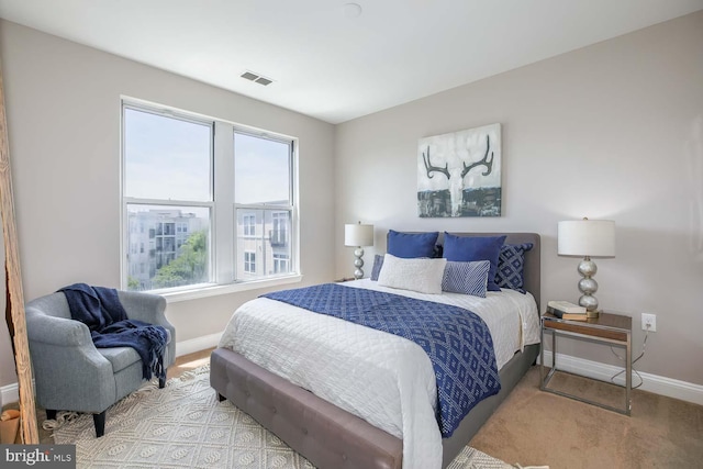 carpeted bedroom featuring baseboards and visible vents