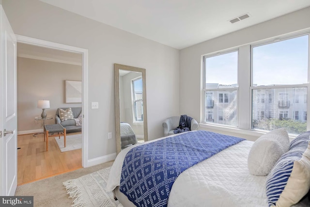 bedroom featuring visible vents, baseboards, and multiple windows