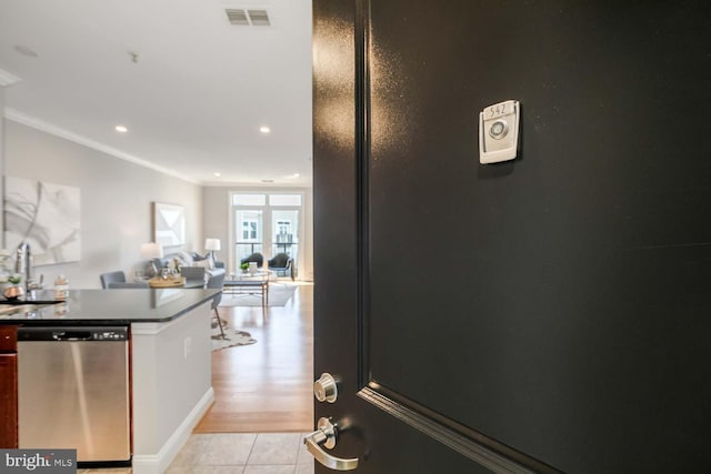kitchen featuring visible vents, crown molding, dishwasher, light tile patterned floors, and open floor plan