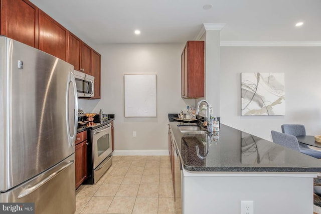 kitchen with ornamental molding, a peninsula, baseboards, a sink, and appliances with stainless steel finishes