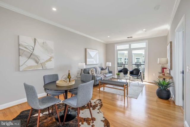 dining space featuring crown molding, recessed lighting, baseboards, and wood finished floors