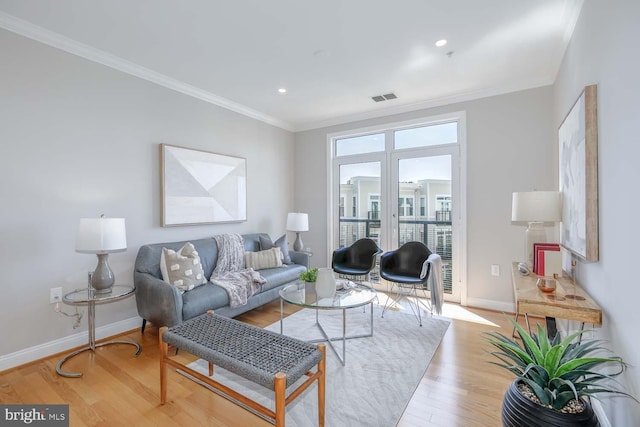 living room with visible vents, wood finished floors, baseboards, ornamental molding, and recessed lighting