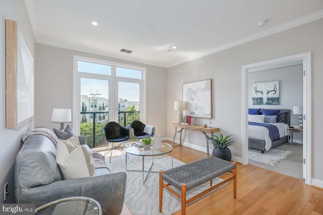 living room with baseboards, ornamental molding, and light wood finished floors