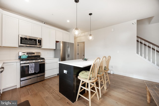 kitchen with appliances with stainless steel finishes, light wood-style flooring, and white cabinetry