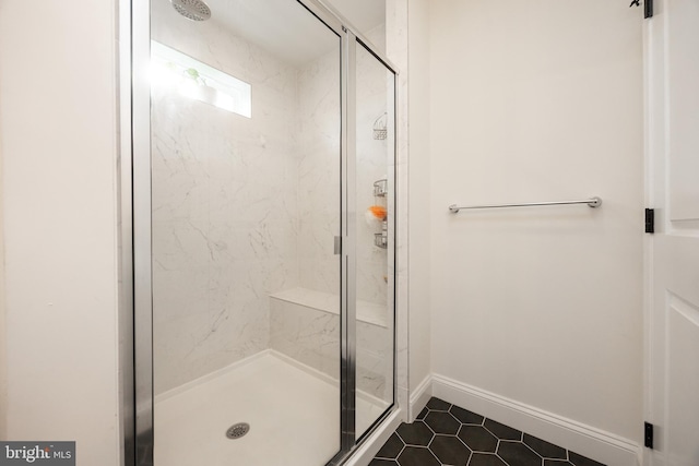 full bathroom with baseboards, tile patterned floors, and a shower stall