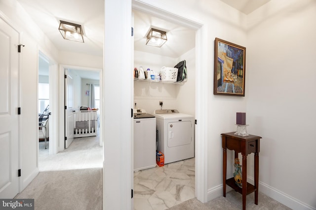 washroom featuring laundry area, washing machine and dryer, baseboards, and light carpet