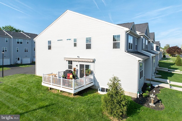 back of house with a lawn and a deck