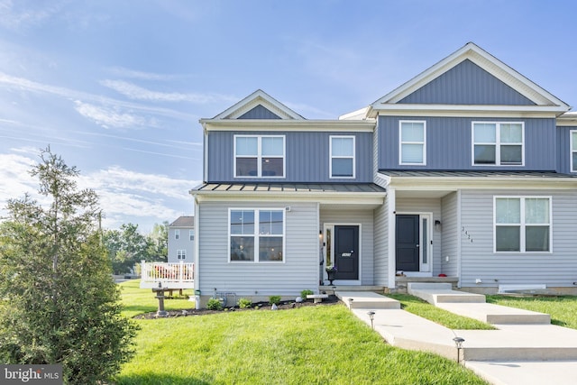 view of front of home with a standing seam roof, metal roof, and a front lawn
