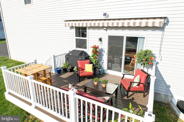 wooden terrace with a grill and outdoor lounge area
